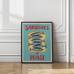 May include: Framed poster with a retro design featuring sardines on toast. The artwork displays six stylized fish atop a slice of toast, set against a teal background. The words "SARDINES" and "on TOAST" are in red.