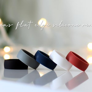 May include: Five silicone rings in different colors: black, gray, blue, white, and red. The rings are flat and have a smooth finish.