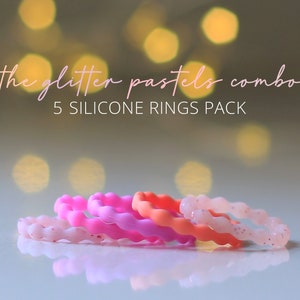 May include: A pack of five silicone rings in pastel colors: light pink, pink, and orange. The rings have a wavy design and glitter accents. Text on the image reads "the glitter pastels combo" and "5 SILICONE RINGS PACK".