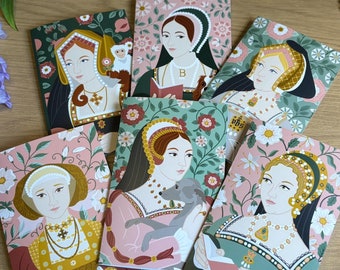 May include: A collection of illustrated greeting cards featuring portraits of historical figures, each with unique floral backgrounds. The cards showcase women in ornate attire, with details like jewelry and headwear. The color palette includes pinks, greens, and golds.