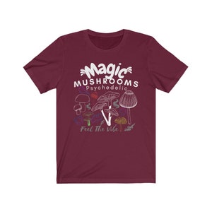 May include: A maroon t-shirt with a white graphic of mushrooms and the text "Magic Mushrooms Psychedelic Feel The Vibe".