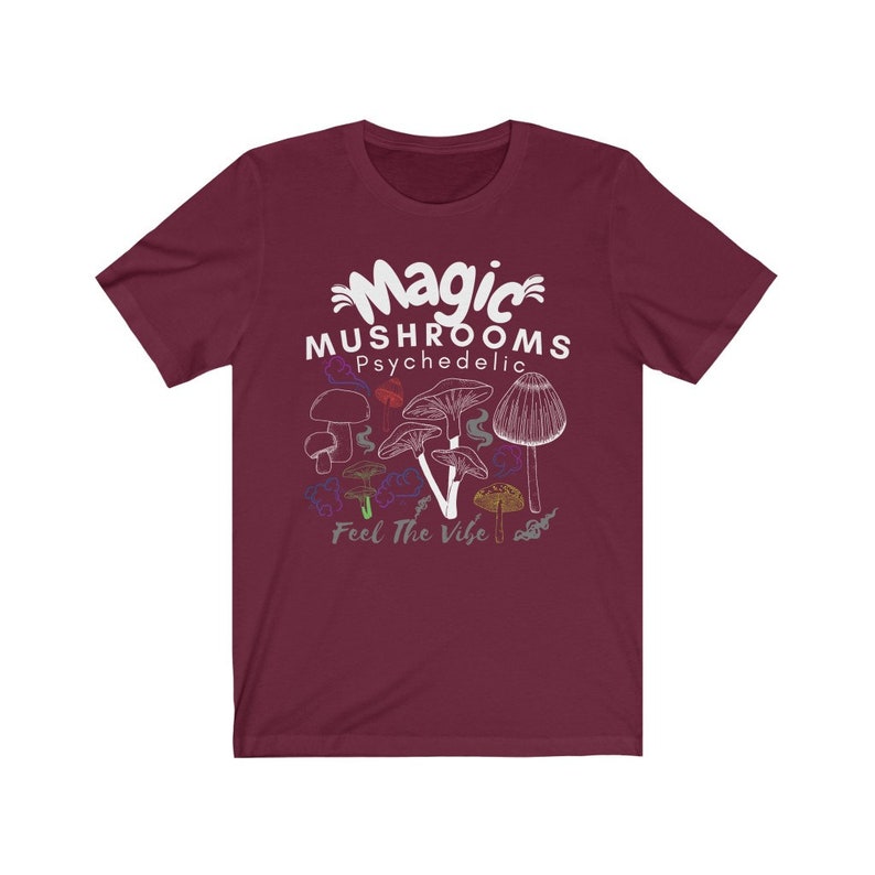 May include: A maroon t-shirt with a white graphic of mushrooms and the text "Magic Mushrooms Psychedelic Feel The Vibe".