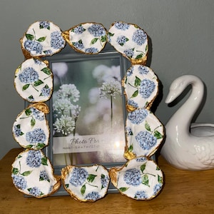 May include: A white ceramic mug with a black handle and the text "But First, Coffee" in a handwritten style. The mug is on a white surface. The mug is approximately 4 inches tall.