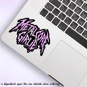 May include: A pink and black sticker with the text "Metalcore Girl" in a stylized font.
