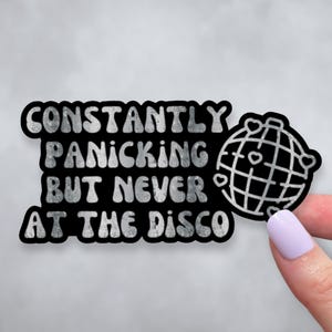 May include: Black and white sticker with the text "Constantly Panicking But Never At The Disco" and a disco ball graphic.