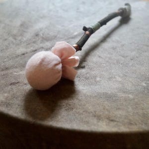 Baqueta chamánica hecha a mano: fieltro rosa, madera y cuero, una baqueta única.