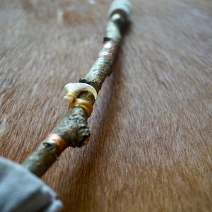 Tambor chamánico hecho a mano: fieltro gris, garra de lince rojo, madera natural