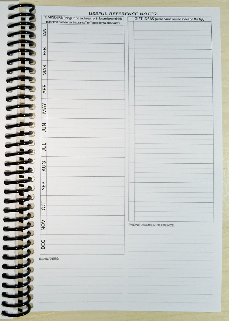 K&ouml;nnte beinhalten: Ein wei&szlig;er Spiralplaner mit Abschnitten f&uuml;r Erinnerungen, Geschenkideen und Telefonnummern. Die linke Seite hat monatliche Spalten von Januar bis Dezember. Oben steht "N&uuml;tzliche Referenznotizen".