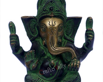 Könnte beinhalten: Eine grüne und goldene Messingstatue von Ganesha, einer hinduistischen Gottheit, mit einem Rüssel, großen Ohren und vier Armen. Die Statue sitzt mit gekreuzten Beinen und trägt eine dekorative Krone auf dem Kopf. Die Statue ist aufwendig detailliert und hat ein traditionelles Design.