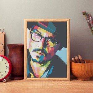 Puede incluir: Un retrato enmarcado de un hombre con un diseño geométrico colorido. El hombre lleva un sombrero y gafas. El marco es de madera y tiene un acabado marrón claro.