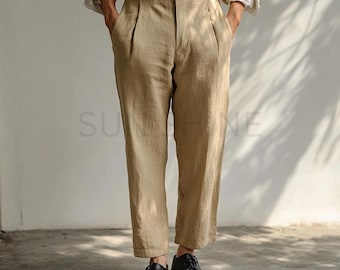 May include: A pair of beige linen pants with a high waist and pleats. The pants have a straight leg and are cropped above the ankle.
