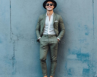 May include: A man wearing a green suit, a white shirt, a black fedora hat, and sunglasses. He is standing in front of a blue wall.
