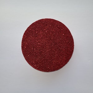 May include: A red glitter circle, perfect for crafting projects or adding a festive touch to your decor.