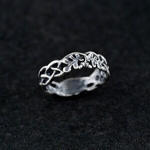 May include: A silver ring with a delicate design of intertwined leaves and branches.