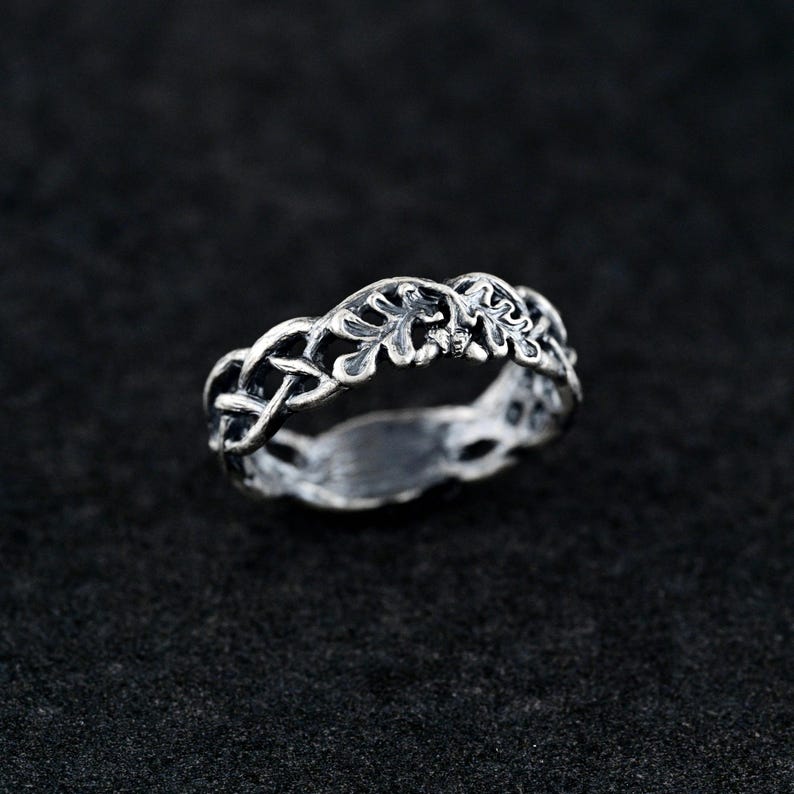May include: A silver ring with a delicate design of intertwined leaves and branches.