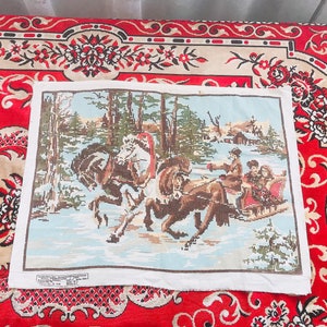 May include: A cross-stitch tapestry depicting a winter scene with a horse-drawn sleigh carrying people through a snowy landscape. The tapestry features a color palette of blues, browns, greens, and whites, with a focus on the details of the figures and the environment.