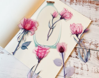 May include: A set of six pink and white floral stickers with a watercolor effect. The stickers are arranged on a white background and feature a variety of floral designs, including roses and other flowers. The stickers are perfect for adding a touch of elegance to any project.