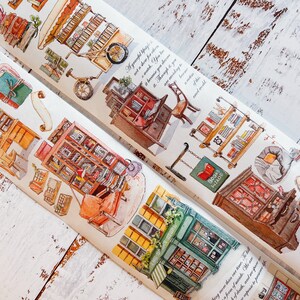 May include: Two rolls of decorative washi tape with watercolour illustrations of bookshelves, furniture, and a bicycle. The tape includes text in English. The colour palette includes shades of brown, orange, and green.