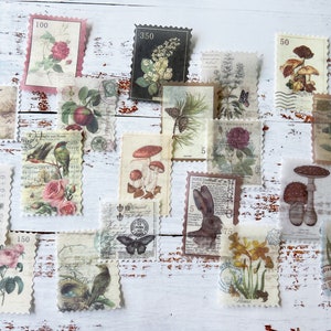 May include: A collection of vintage-style postage stamps featuring botanical and nature illustrations. The stamps showcase images of flowers, birds, mushrooms, and a rabbit, with varying denominations and decorative borders. The stamps are arranged on a white wooden surface.