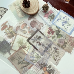 May include: A collection of vintage-style decorative stickers with various botanical and nature-themed designs. The stickers feature images of mushrooms, flowers, butterflies, and a rabbit, with a postage stamp border. The color palette includes soft pastels and sepia tones.