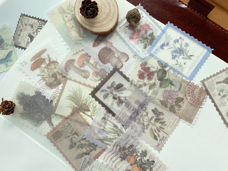 May include: A collection of vintage-style decorative stickers with various botanical and nature-themed designs. The stickers feature images of mushrooms, flowers, butterflies, and a rabbit, with a postage stamp border. The color palette includes soft pastels and sepia tones.