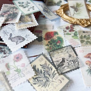 May include: A collection of vintage-style postage stamps featuring botanical illustrations, animals, and mushrooms. The stamps have scalloped edges and include numbers and text. The color palette includes muted greens, browns, and creams, creating a nostalgic aesthetic.