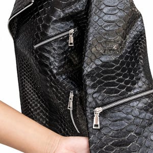 Close-up of black genuine python snakeskin leather jacket texture and zipper details