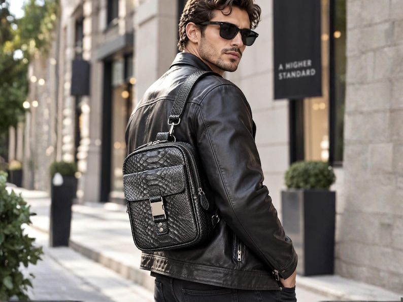 Man wearing black python snakeskin sling backpack with leather jacket in luxury city setting