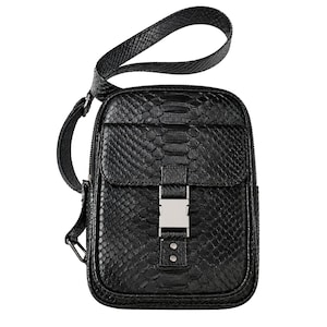 Front view of black genuine python leather crossbody backpack with flap pocket and silver buckle