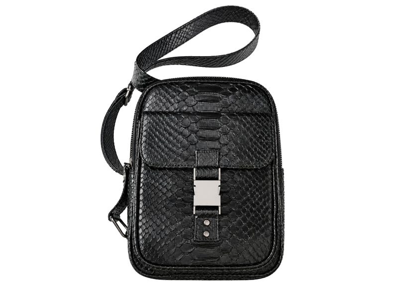 Front view of black genuine python leather crossbody backpack with flap pocket and silver buckle