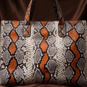 Luxury vanity styling with orange snakeskin tote bag and elegant accessories
