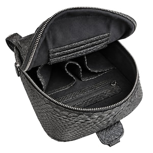 Open black python snakeskin backpack showing spacious interior, organizer pockets and zippered compartment