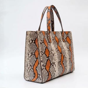Side angle of exotic python leather tote bag with shoulder straps