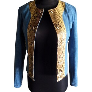 Op de afbeelding: Een blauwe blazer met een slangenhuidpatroon aan de voor- en achterkant. De blazer heeft een kraag en lange mouwen.