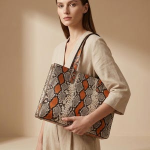 Elegant woman carrying orange genuine python snakeskin shoulder tote bag