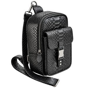 Black genuine python leather crossbody sling backpack angled view showing front pocket zipper and buckle