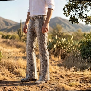 Calças boca de sino masculinas em couro exótico de píton, nas cores cinza e bege.