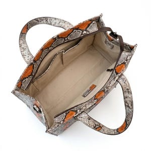 Interior compartment of luxury python leather tote bag with organizer pockets