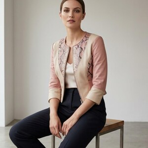 Seated model wearing blush python leather jacket chic outfit