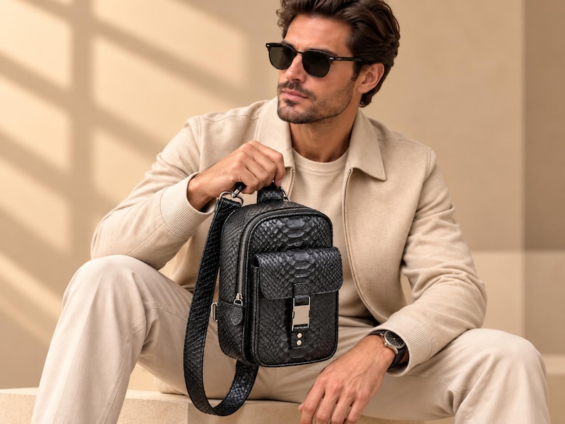 Stylish man holding genuine black python leather sling backpack with adjustable crossbody strap