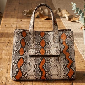 Genuine python leather handbag displayed on rustic wooden table