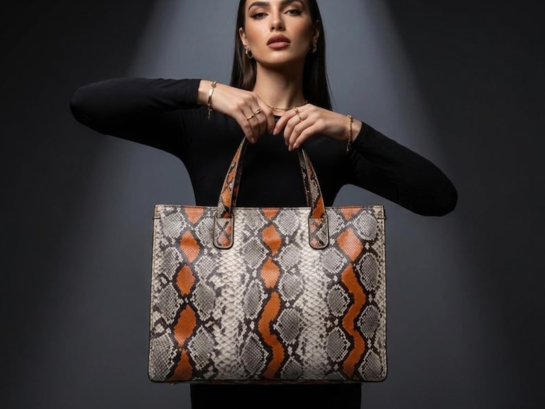 Fashion model holding luxury exotic python leather tote handbag