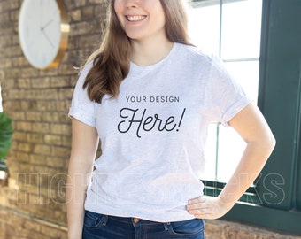 Peut inclure: Un t-shirt blanc avec le texte "YOUR DESIGN Here!" imprimé sur le devant. Le t-shirt est porté par une personne aux cheveux longs et bruns.
