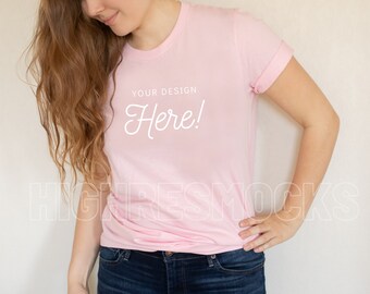Puede incluir: Una mujer con una camiseta rosa con el texto "YOUR DESIGN Here!" impreso en la parte delantera. Lleva pantalones vaqueros azules y tiene el pelo largo y castaño.