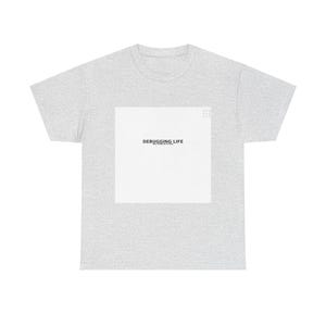 Może przedstawiać: Jasnoszary t-shirt z krótkim rękawem z dużą białą kwadratową grafiką na klatce piersiowej. Grafika zawiera czarny napis "DEBUGGING LIFE", mniejszy tekst poniżej oraz małą ikonę siatki w prawym górnym rogu.