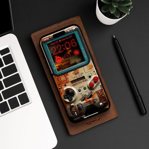 Pode incluir: Uma capa de telefone de couro marrom com um design de videogame retrô. A capa apresenta uma imagem pixelada de um console de jogos com um relógio digital que mostra "22:06" e o texto "GETCO 90R".