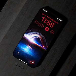 May include: A black smartphone with a dark space-themed wallpaper. The time is 11:58 and the date is Sun 24. The screen also shows a Bitcoin price of £43,583.08.