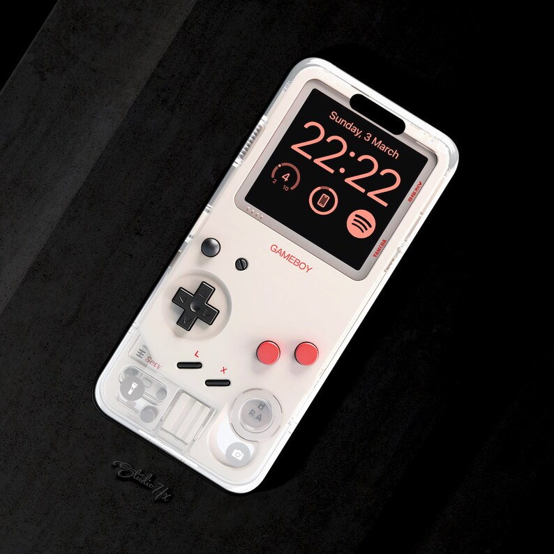 May include: A white phone case with a clear back and a Game Boy design. The case features a black and white Game Boy screen with a digital clock displaying "22:22" and the text "Sunday, 3 March". The case also has red buttons and a black directional pad.