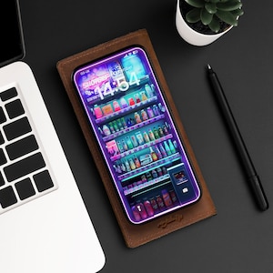 Peut inclure: Un smartphone affichant une scène de supérette éclairée au néon, posé sur un portefeuille en cuir marron. L'écran montre des étagères remplies de produits. Un ordinateur portable et un stylo sont également visibles.
