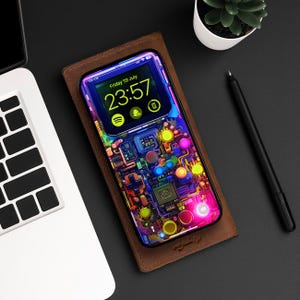 May include: A black phone case with a colorful, abstract design that resembles a circuit board. The phone screen displays the time "23:57" and the date "Friday 19 July".